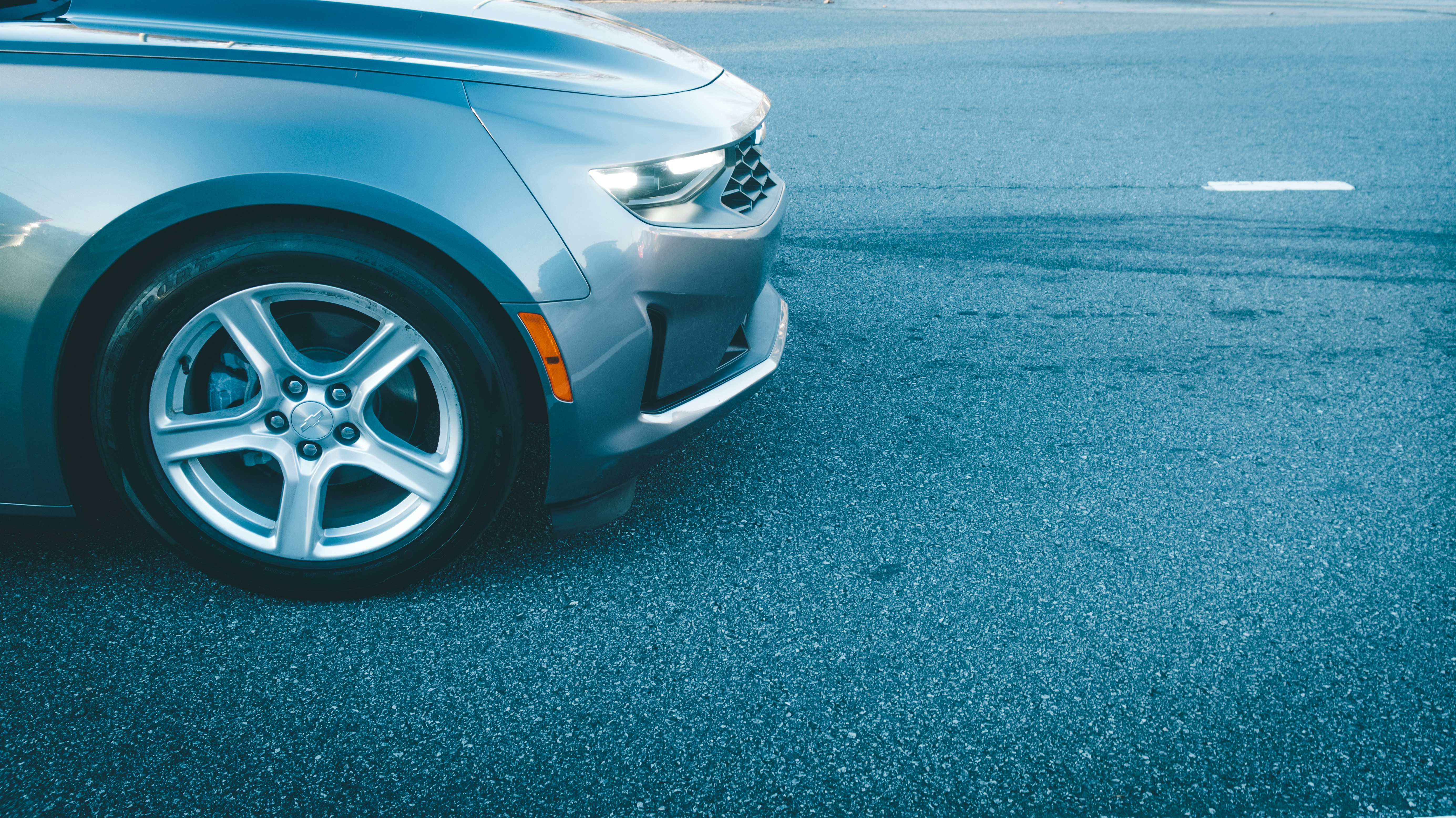 the front of a silver Chrysler sedan on a paved road 