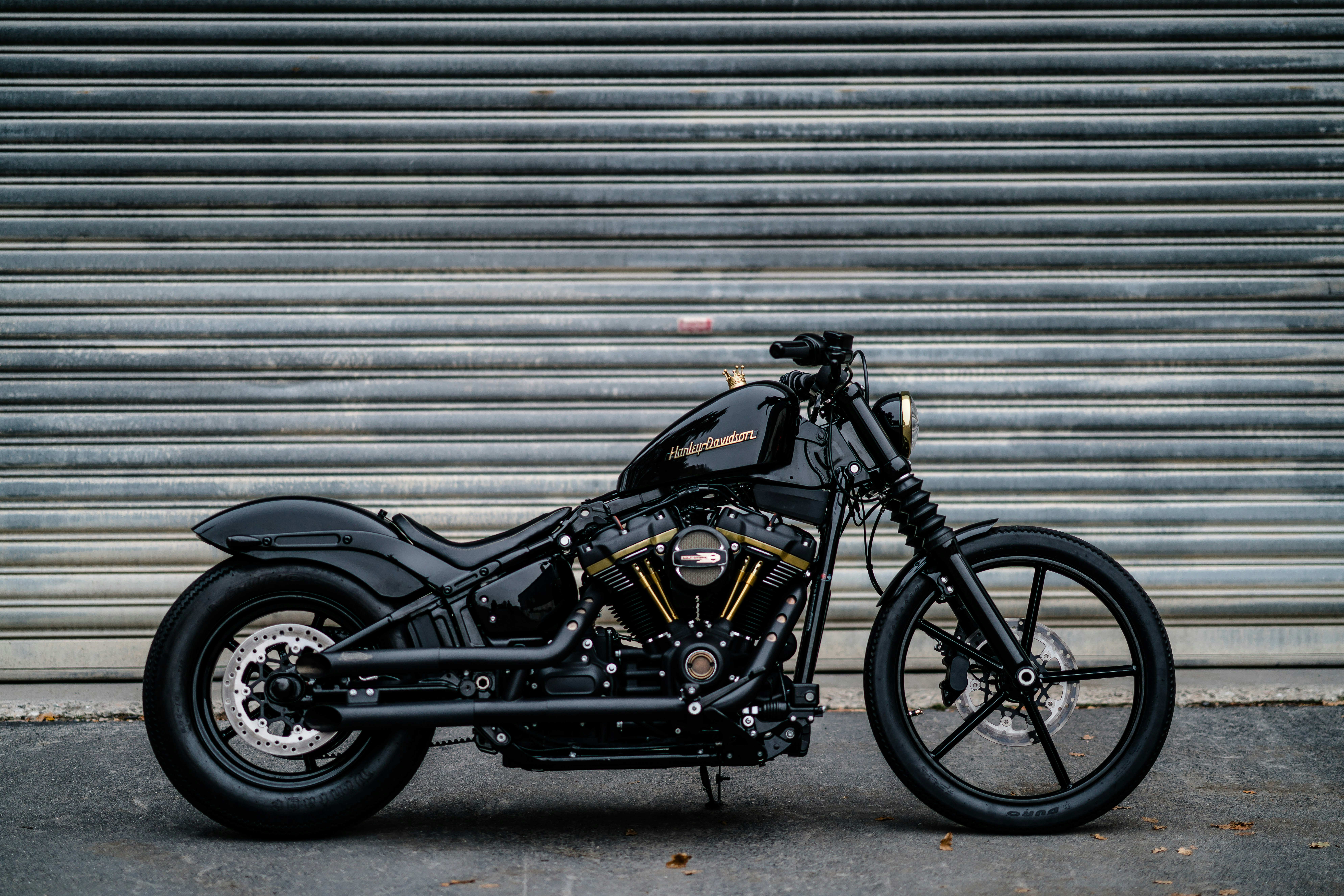 a black Harley Davidson parked in front of a closed metal storefront gate