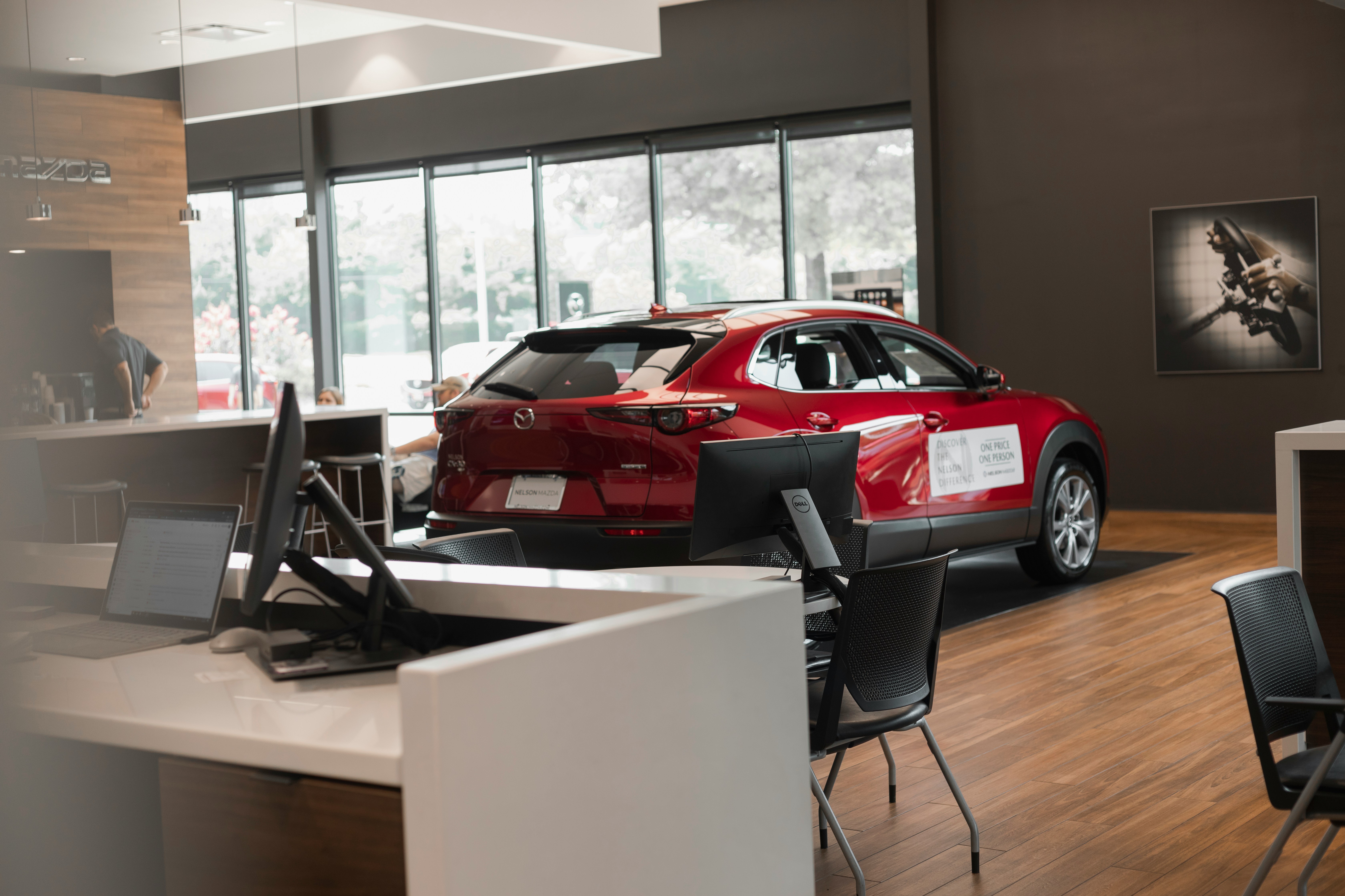 Red SUV inside dealership office, surrounded by desks and chairs. Car loan negotiation