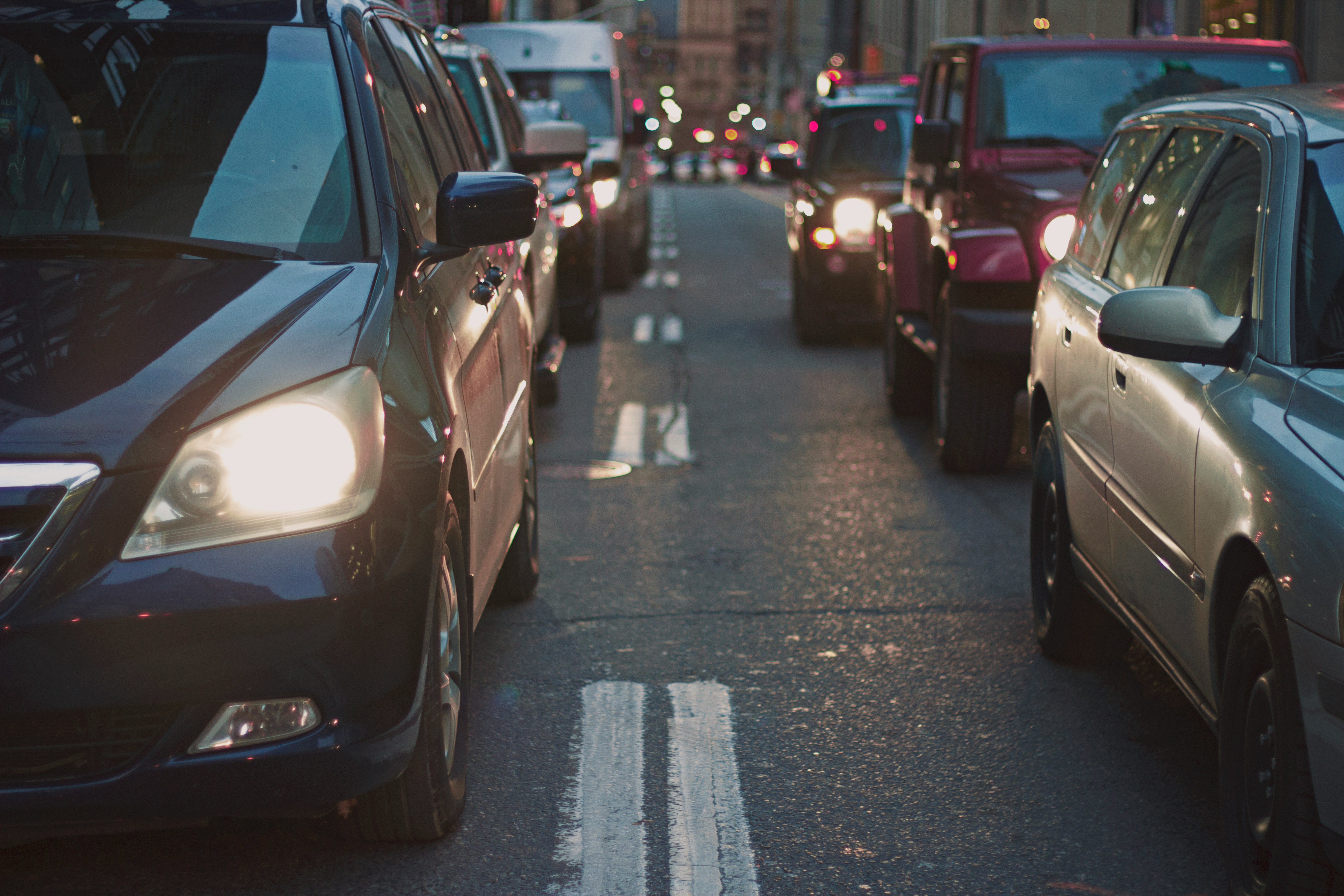 a row of cars in traffic at dusk