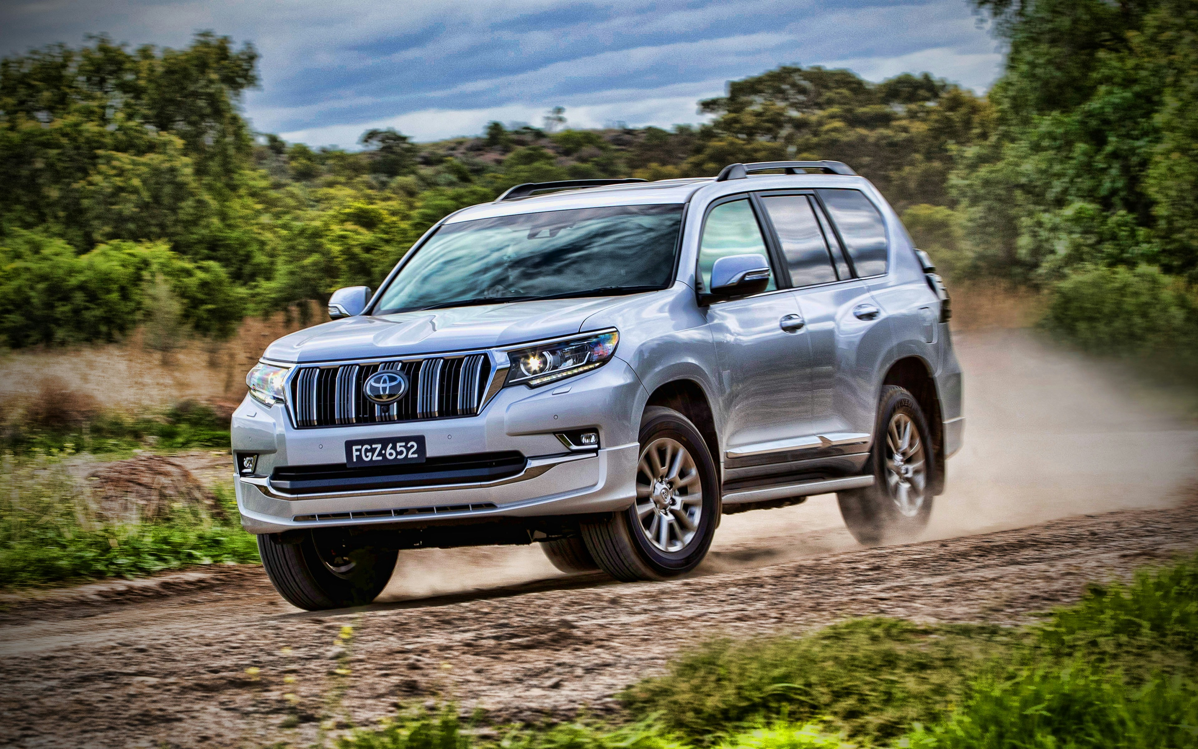 silver SUV driving on dirt road