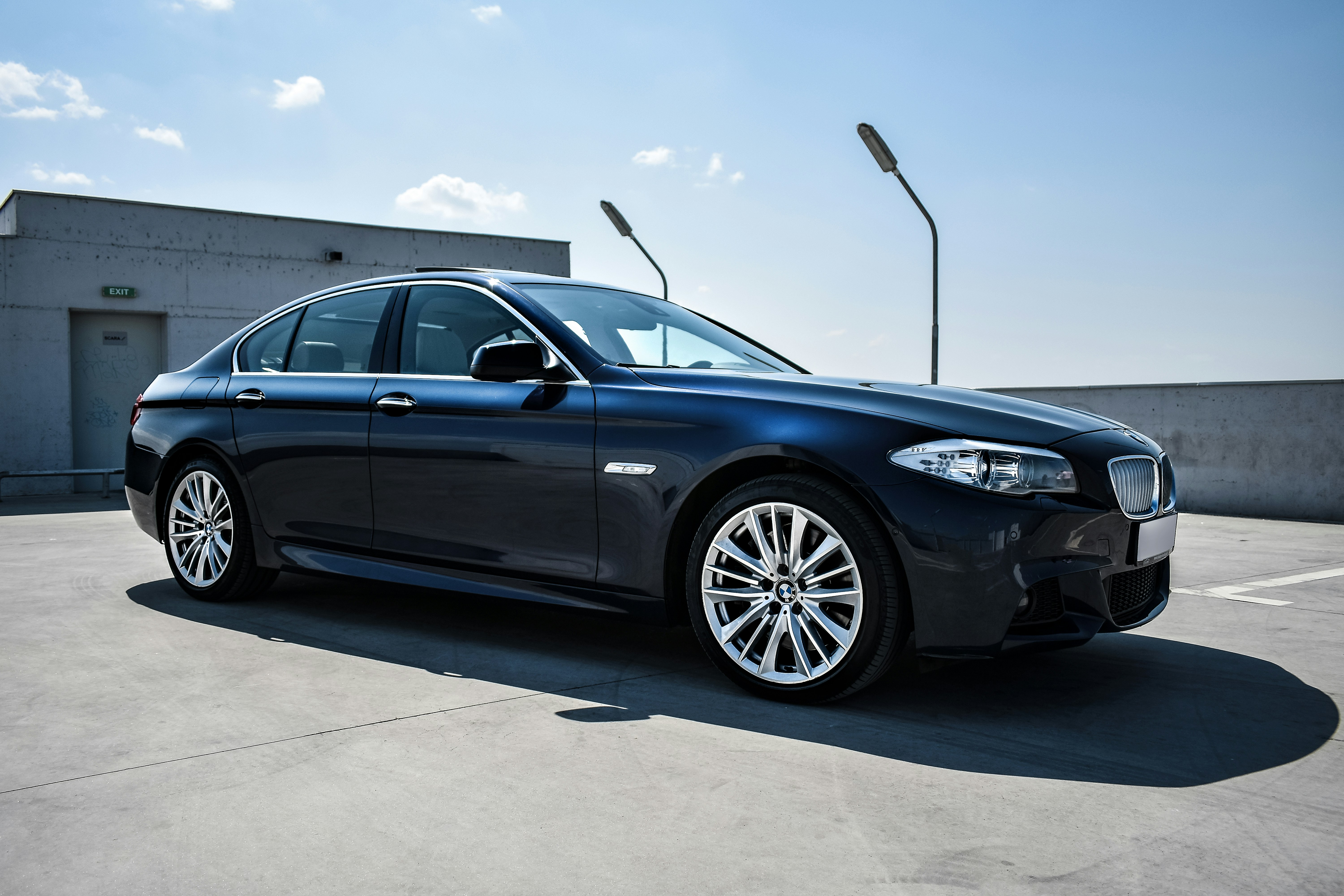 dark blue sedan parked on top level of car park