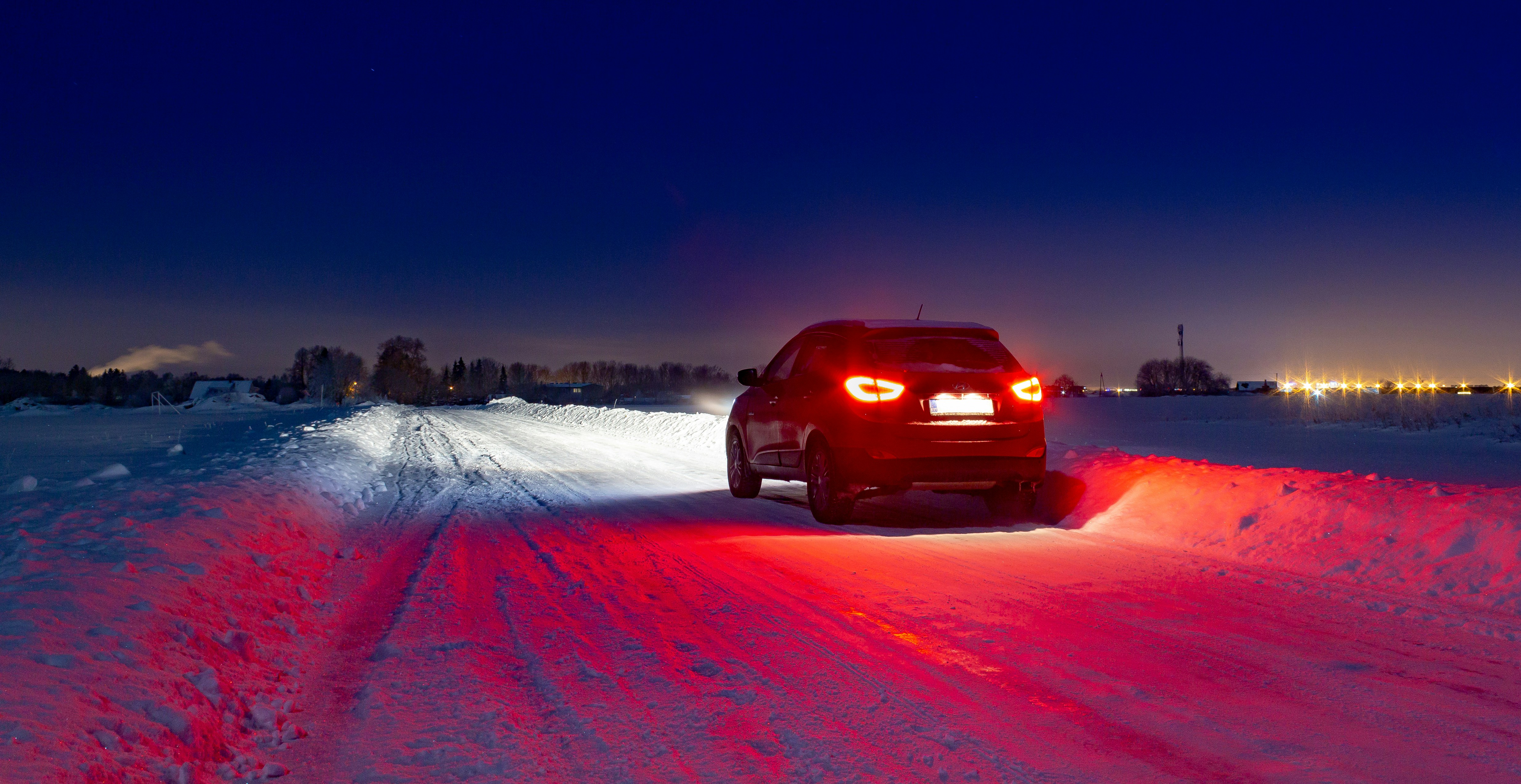 SUV parked on snowy road at night