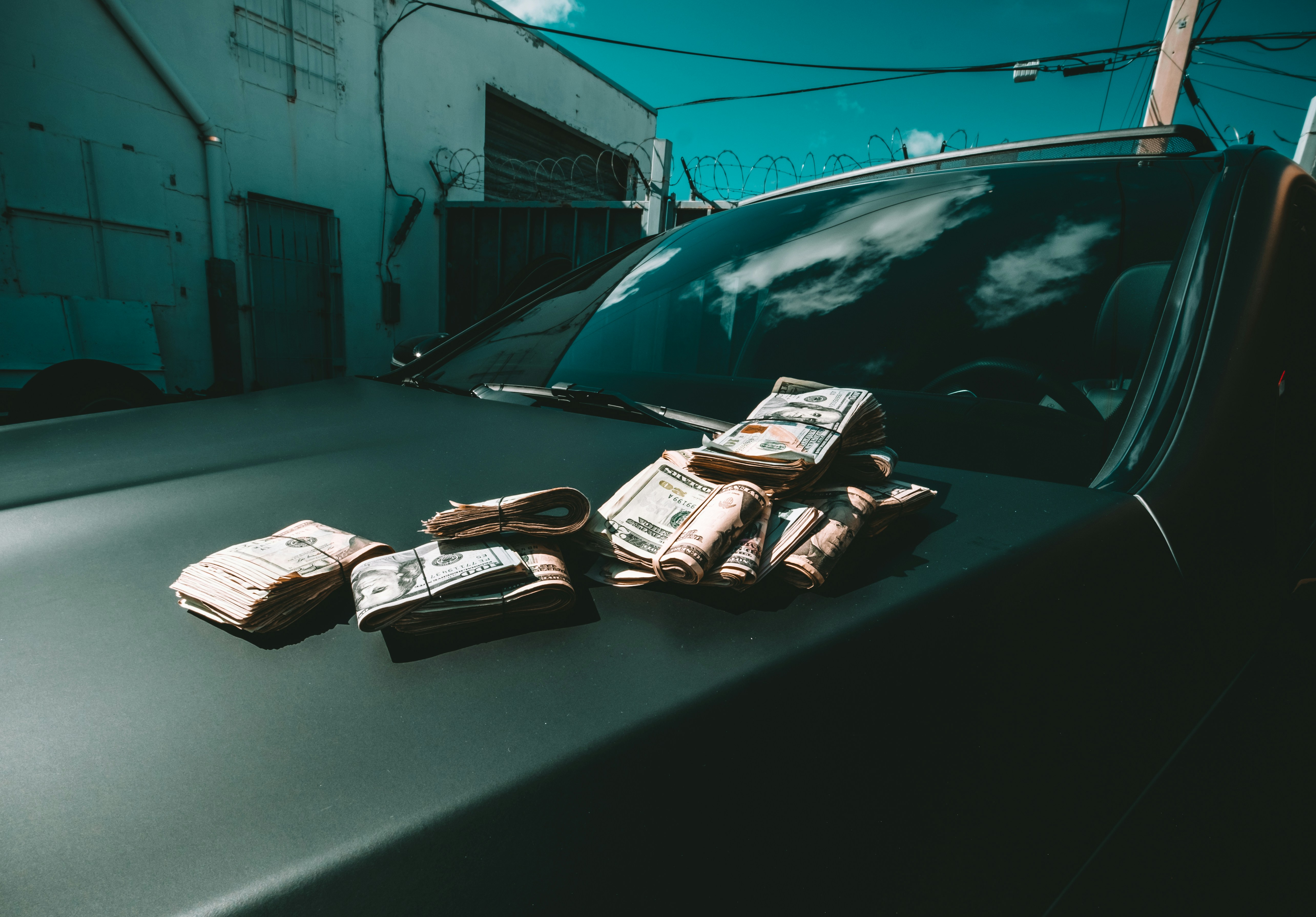 wads of money on the hood of a car