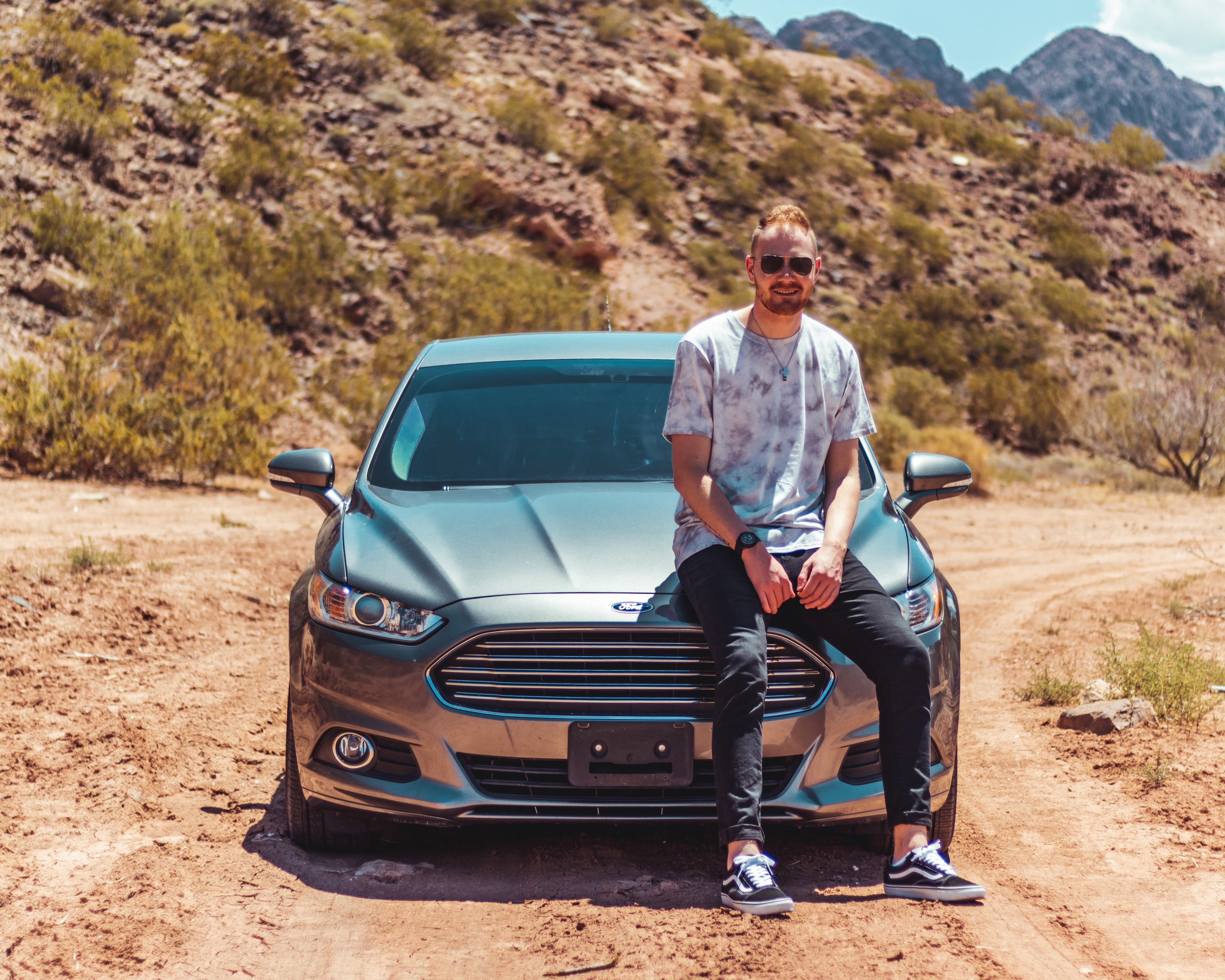 chill man leaning on car in desert
