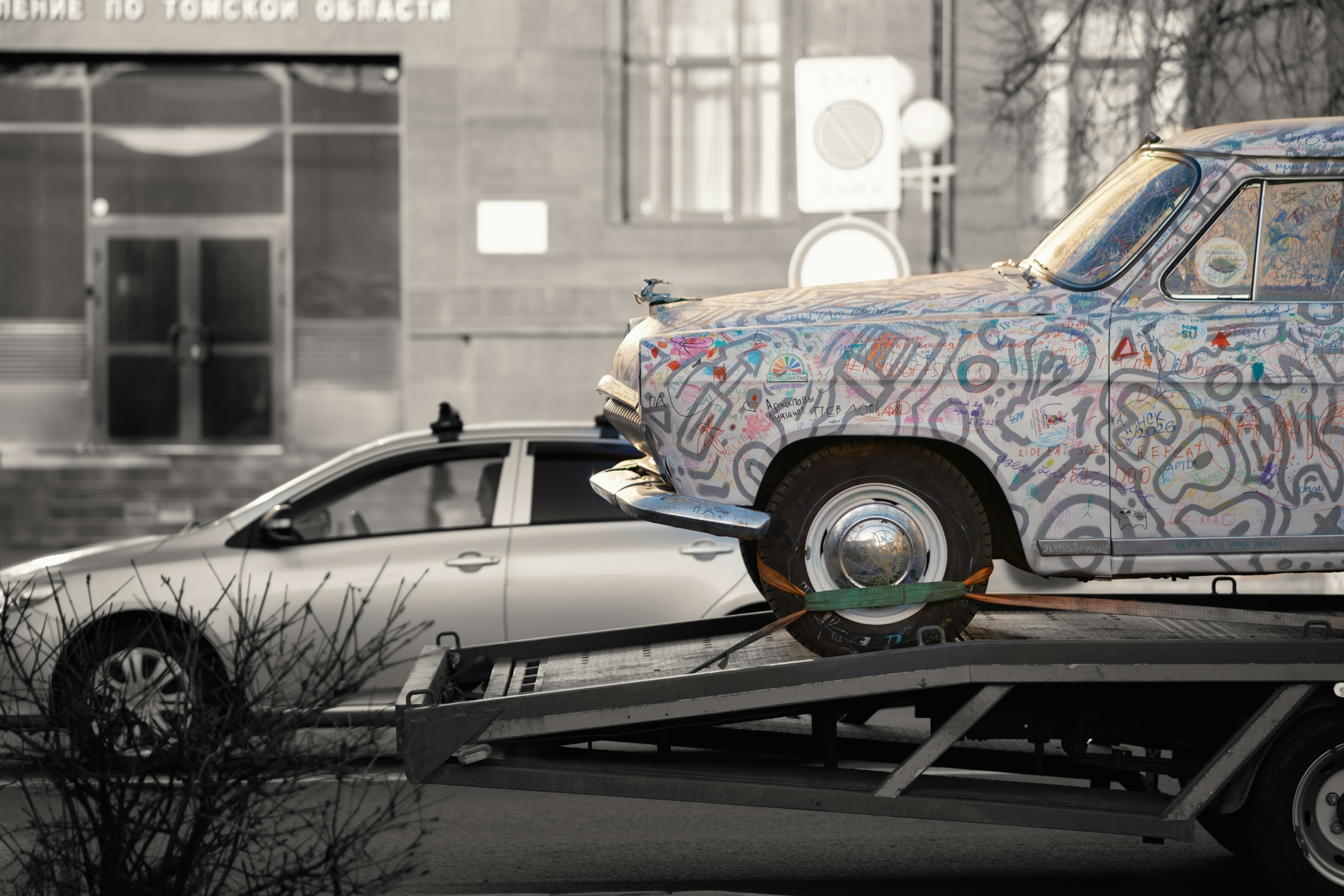 Car covered in graffiti on tow truck