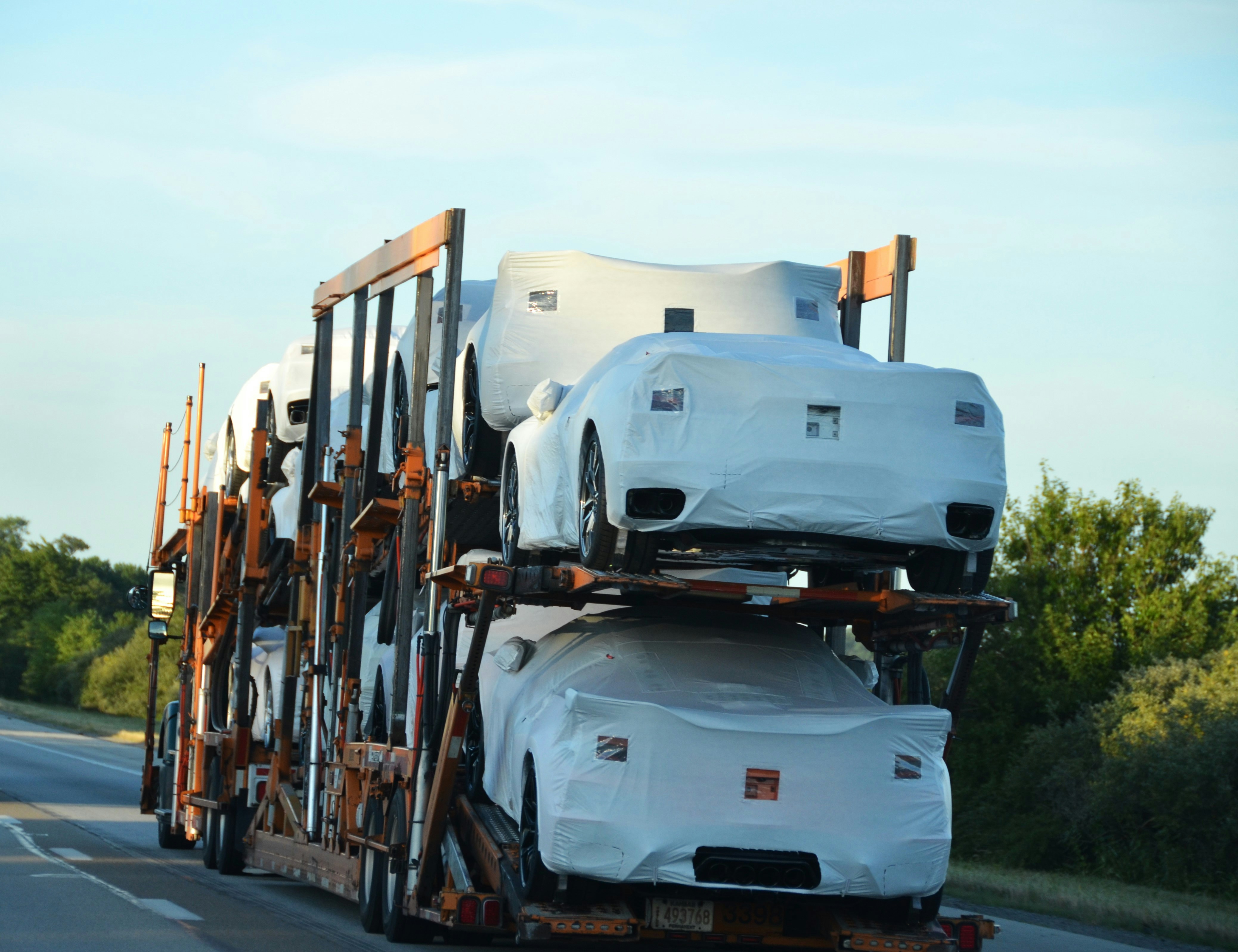 Wrapped new cars being transported by truck