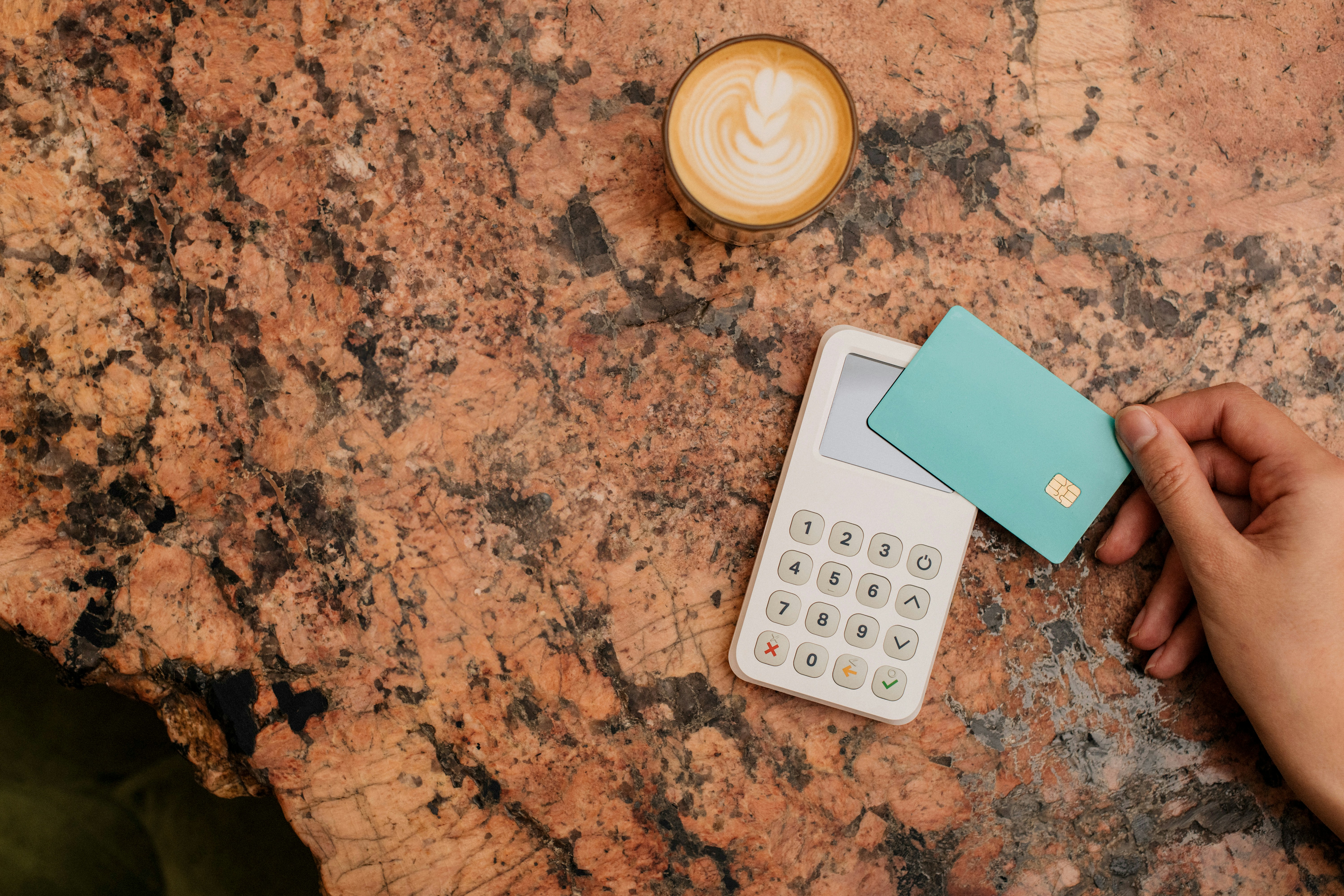 Person tapping credit card, a latte