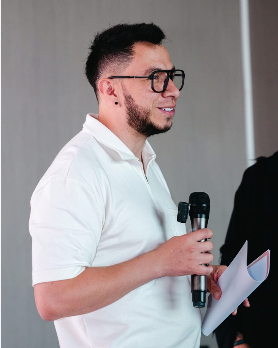 Exon Gaitán hablando con micrófono frente a un grupo