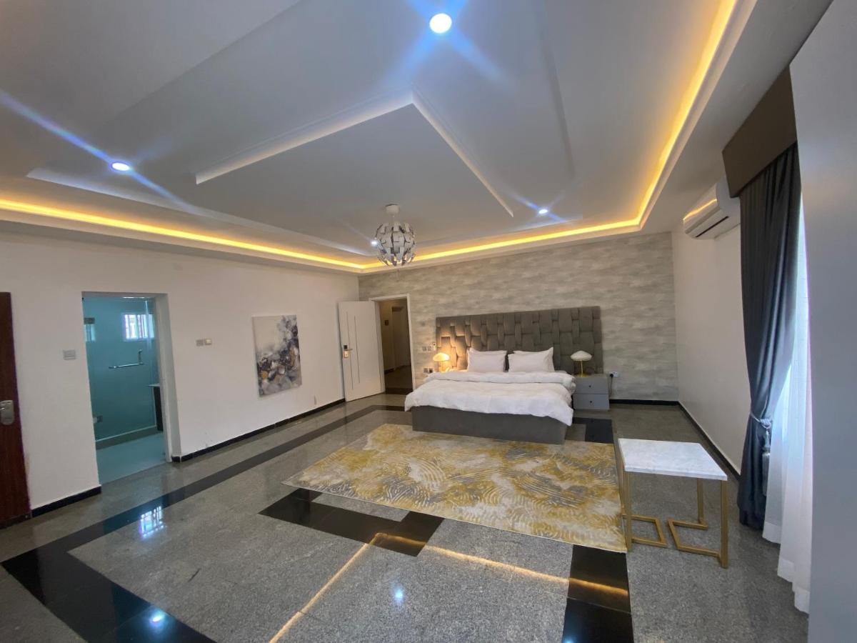 Spacious bedroom with dramatic ceiling lighting and modern design