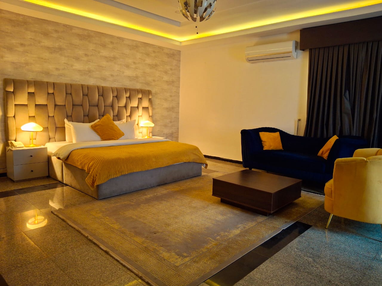 Spacious bedroom with dramatic ceiling lighting and modern design