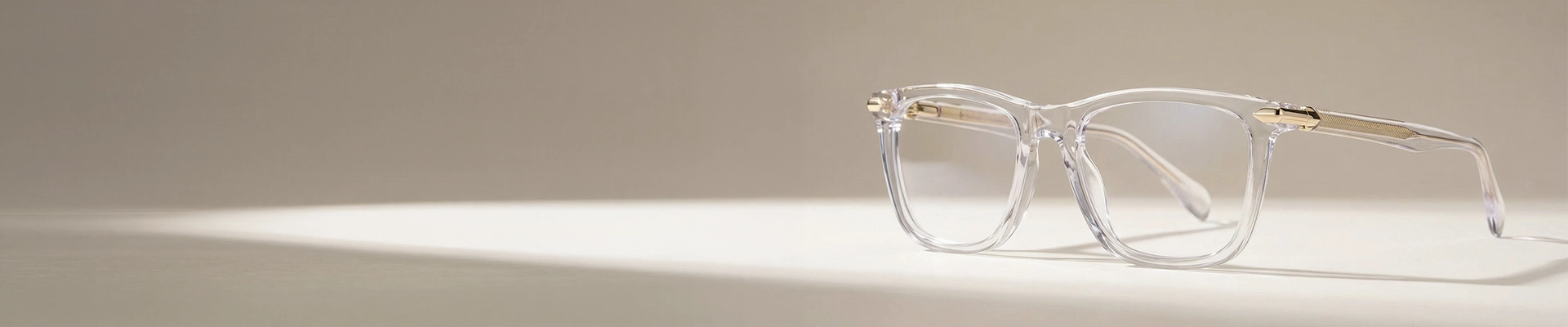 The image features a close-up of clear acetate eyeglasses in a chunky rectangular frame that is placed on a white stand against a light grey background. The image has content that says Clear Glasses. It also has a discount offer by Specscart and Trustpilot reviews.