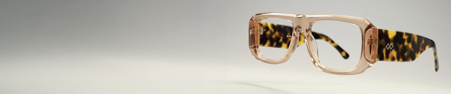 Amber oversized Specscart glasses with bold geometric frames, displayed closed on a cream textured fabric background.