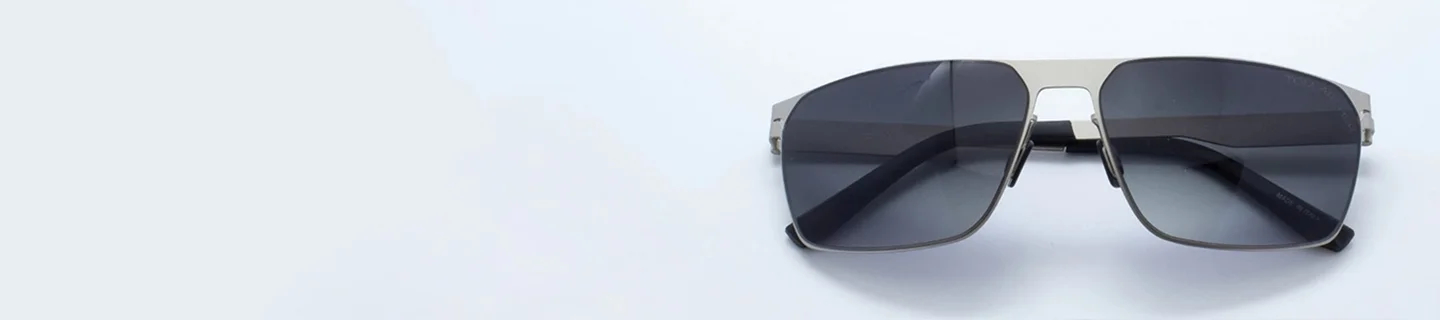 Sleek silver metal flat top sunglasses with dark tinted lenses and thin temples, displayed against a minimalist white background for a modern look.