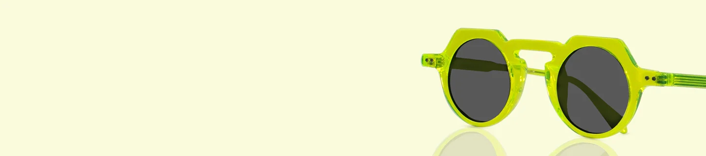 Vibrant neon green translucent round sunglasses with thick frames and dark lenses, casting a subtle reflection on a soft yellow gradient backdrop.