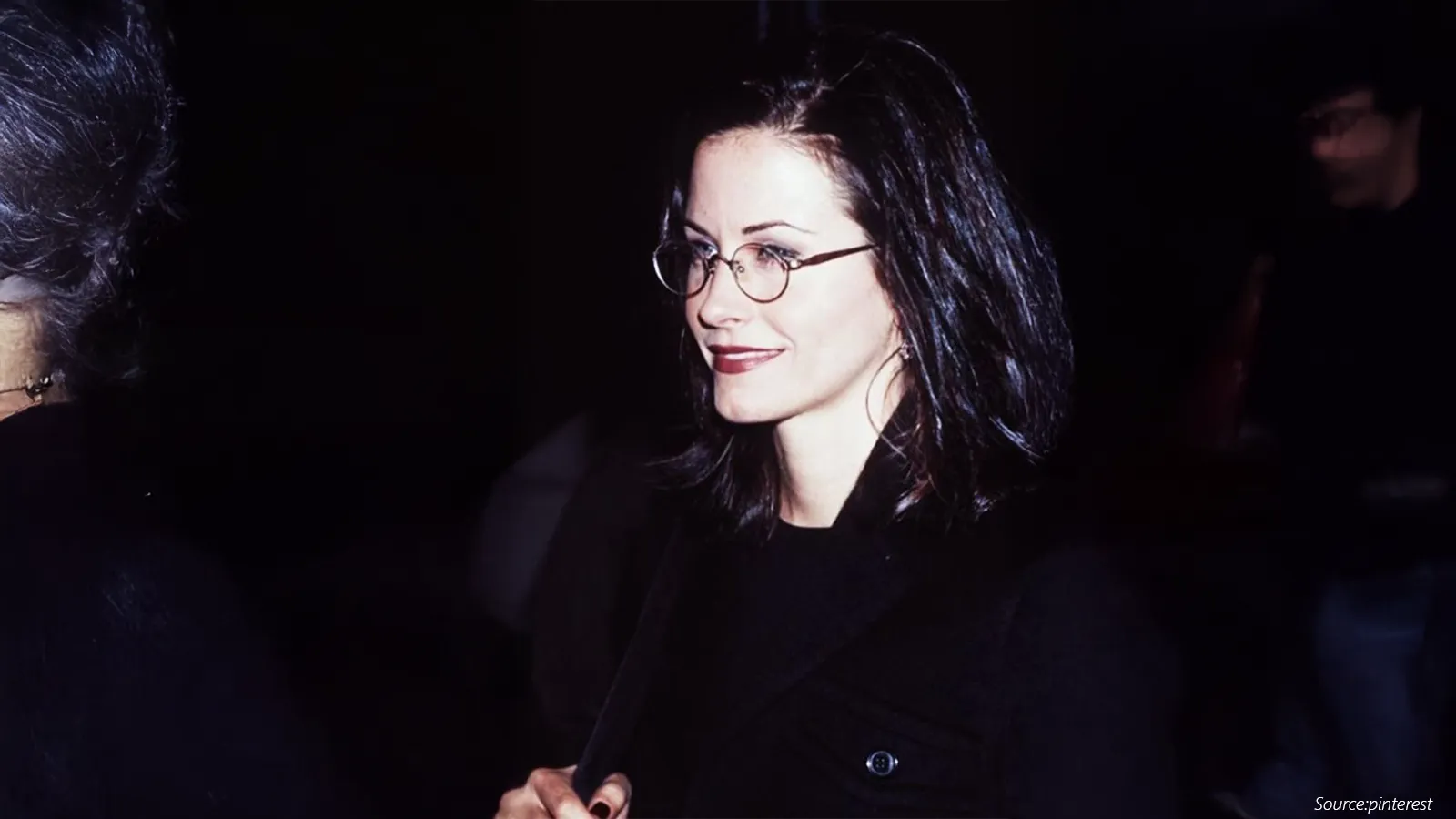 A candid 90s moment captures Courteney Cox in sleek round metal eyeglasses, embodying the era’s minimalist fashion. Her dark hair, confident smile, and understated frames highlight the timeless elegance and intellectual charm that defined the decade’s eyewear style.