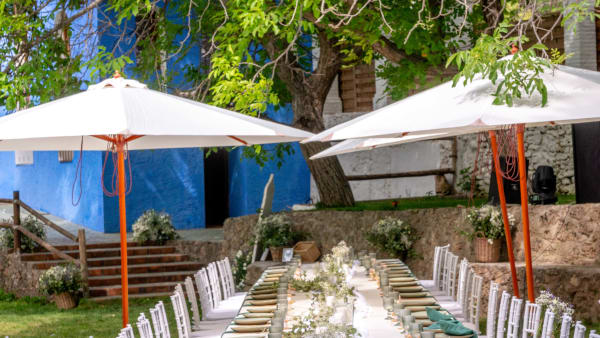 Mesa imperial para boda en cortijo de Granada — montaje exterior con vajilla verde y cubertería dorada