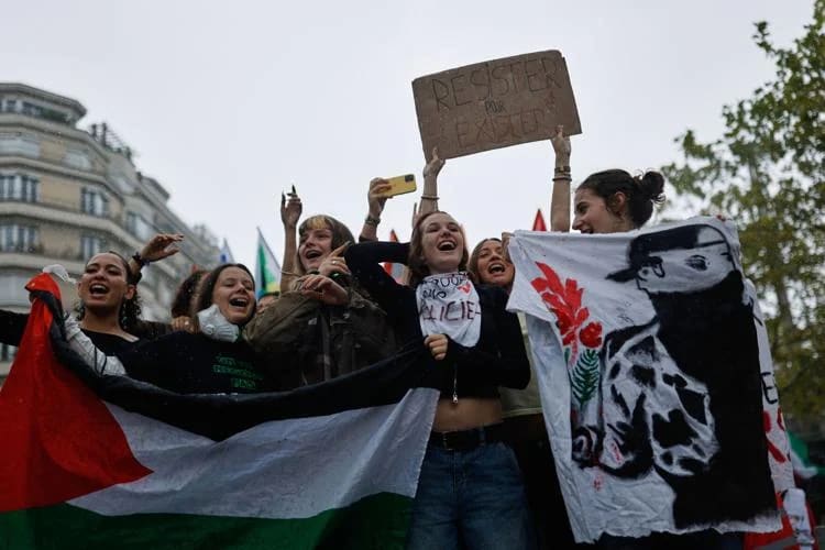 Protesters holding banners during a demonstration in a city street.
