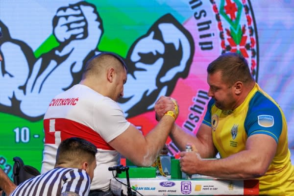 Armwrestling match with intense focus and competition.