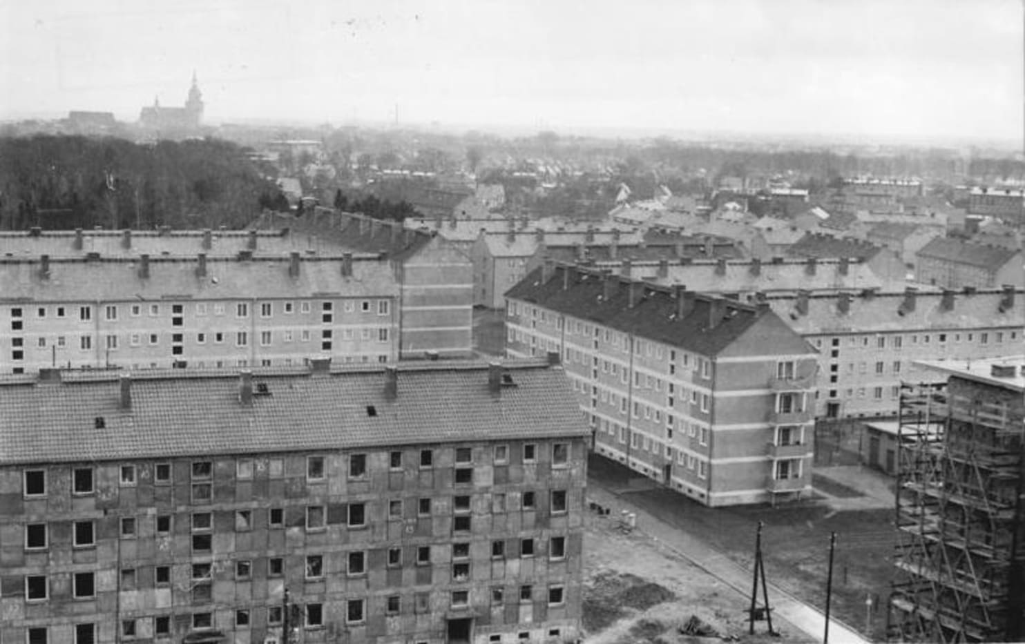 Zentralbild Burmeister 14.5.1962. Plattenbauweise jetzt auch in Stralsund. Mit der Montage der ersten Bauplatte auf der Stralsunder Wohnungsbaustelle in der Kniepenvorstadt hielt jetzt auch der alten Werft- und Hafenstadt eine der fortschrittlichsten Baumethoden Einzug. Bereits vor Wochen wurde in unmittelbarer Nähe des Bauplatzes ein Plattenwerk in Betrieb genommen. Noch in diesem Jahr werden mit der Plattenbauweise in Stralsund sechs Wohnblöcke mit insgesamt 192 Wohnungseinheiten montiert. UBz: Blick vom Hochhaus auf den noch in Kleinplattenverfahren errichteten Teil der Kniepenvorstadt von Stralsund.