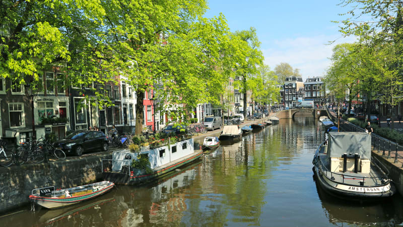Kanal i Amsterdam kantad av båtar