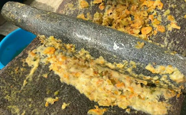 Grinding the ingredients in the metate,