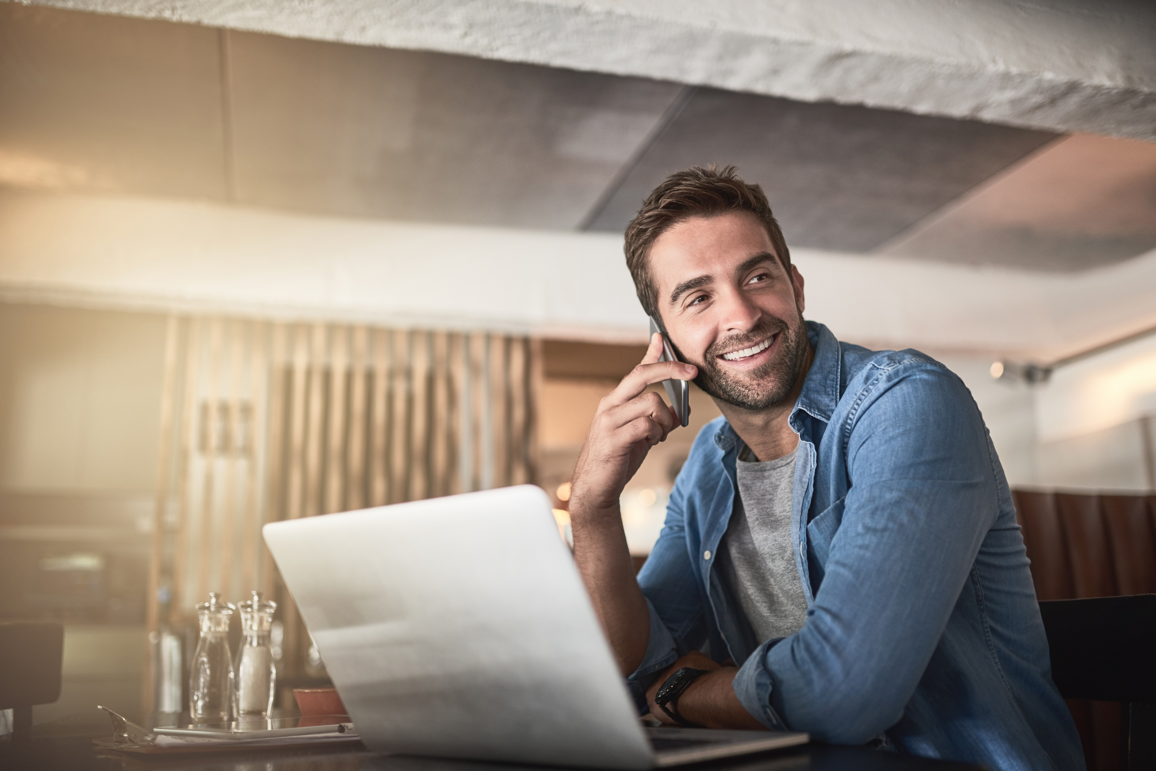 Hombre feliz usando laptop en café