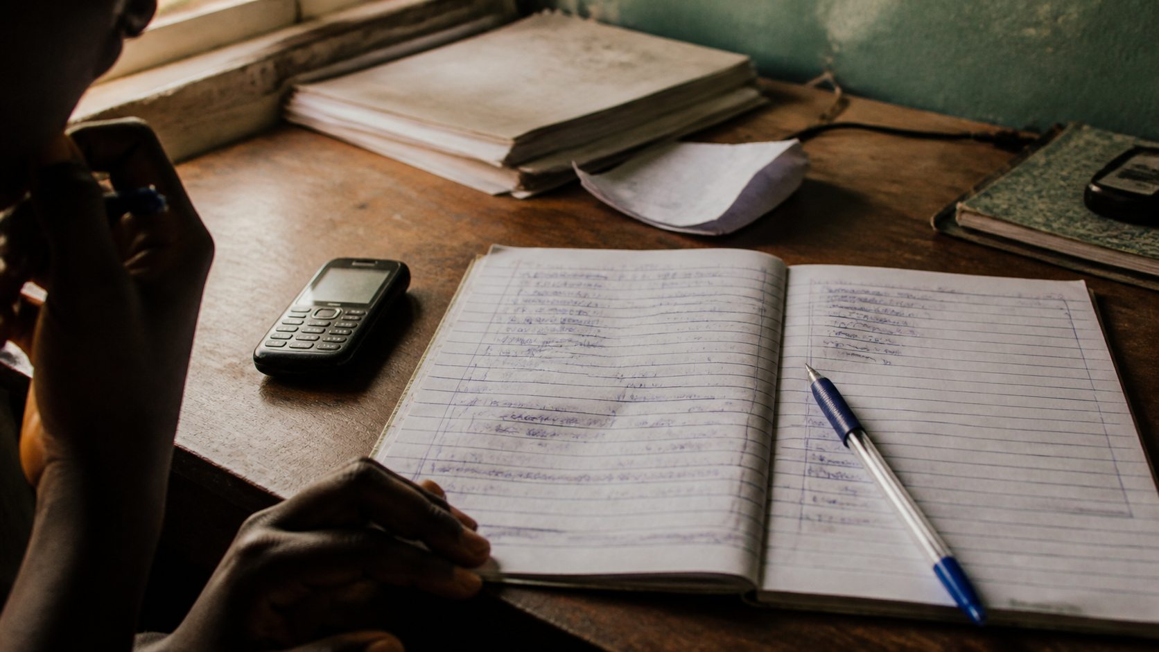 a button phone beside handwritten music post notes
