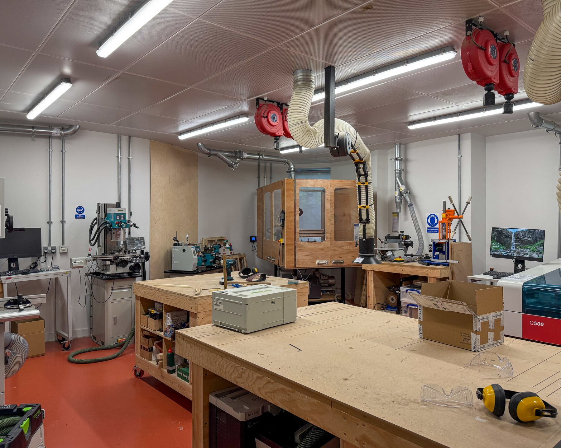 Main prototyping workshop at Plus X Innovation Brighton with CNC enclosure, large-format laser cutter and central assembly bench