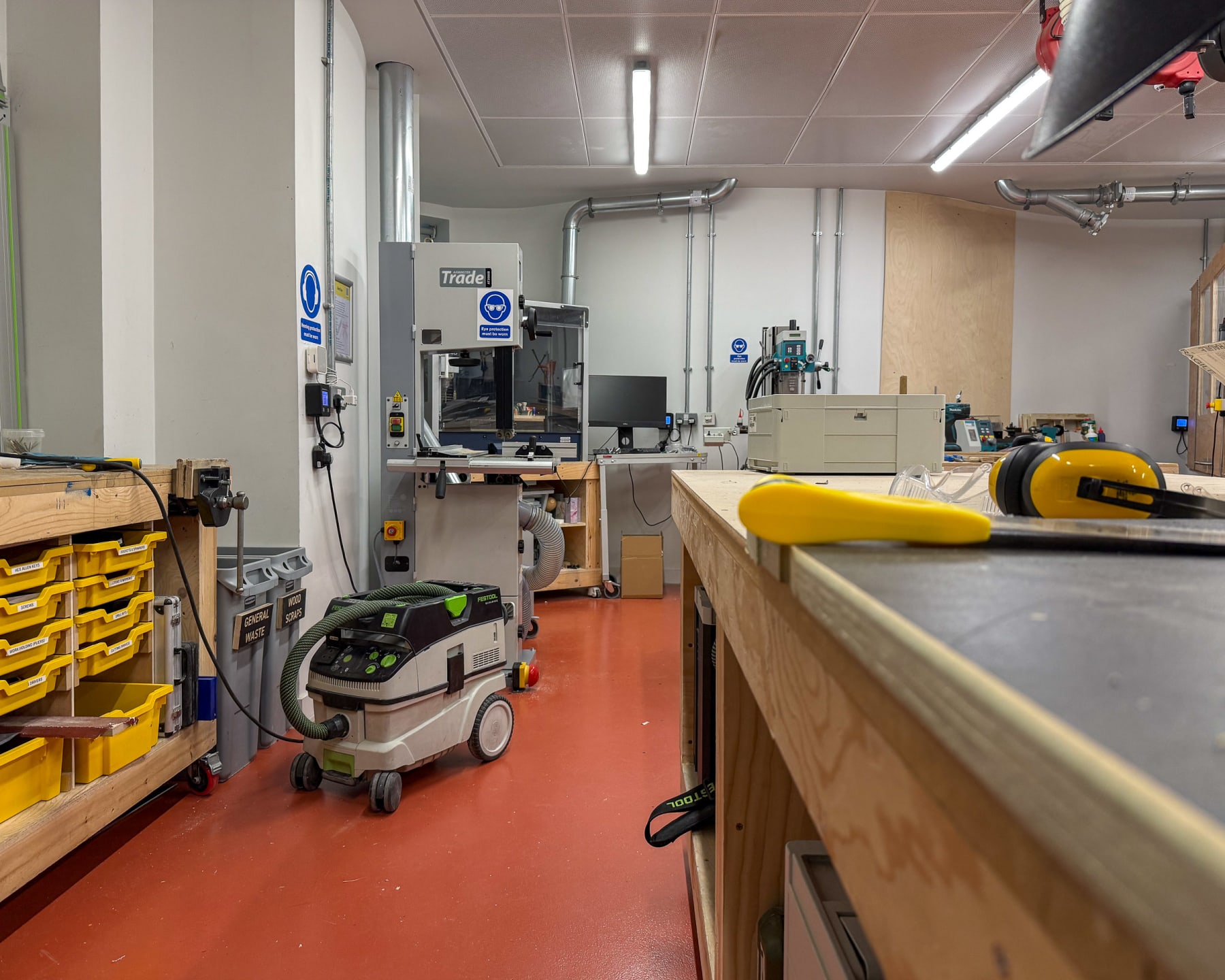 Wide view of the workshop floor showing benches, machines and extraction