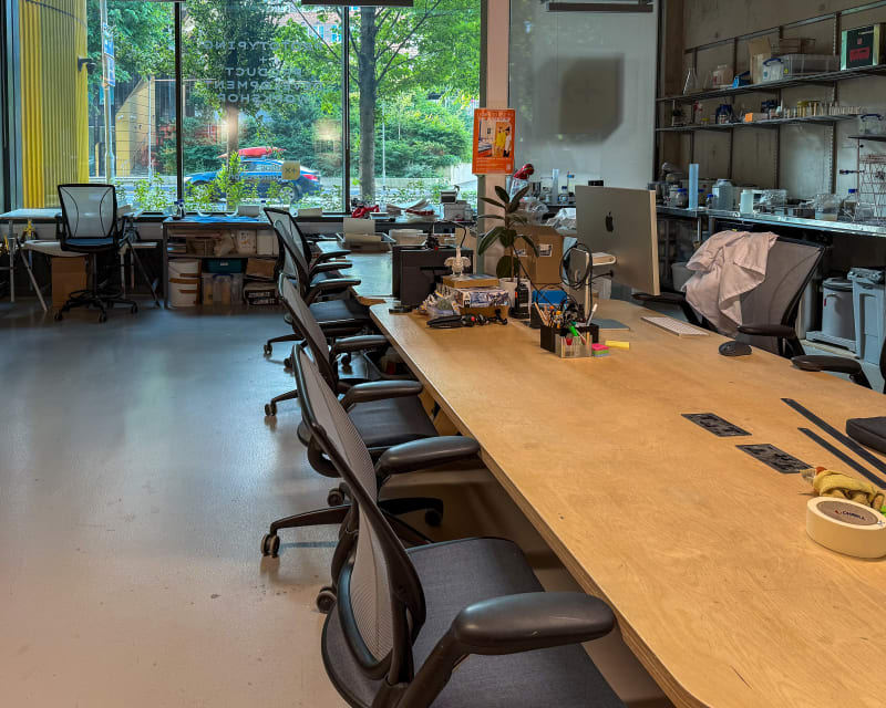 Long communal assembly-area workbench at Plus X Innovation Brighton