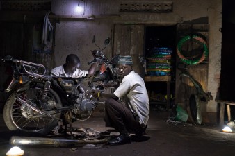Two men work in motorcycle repair shop