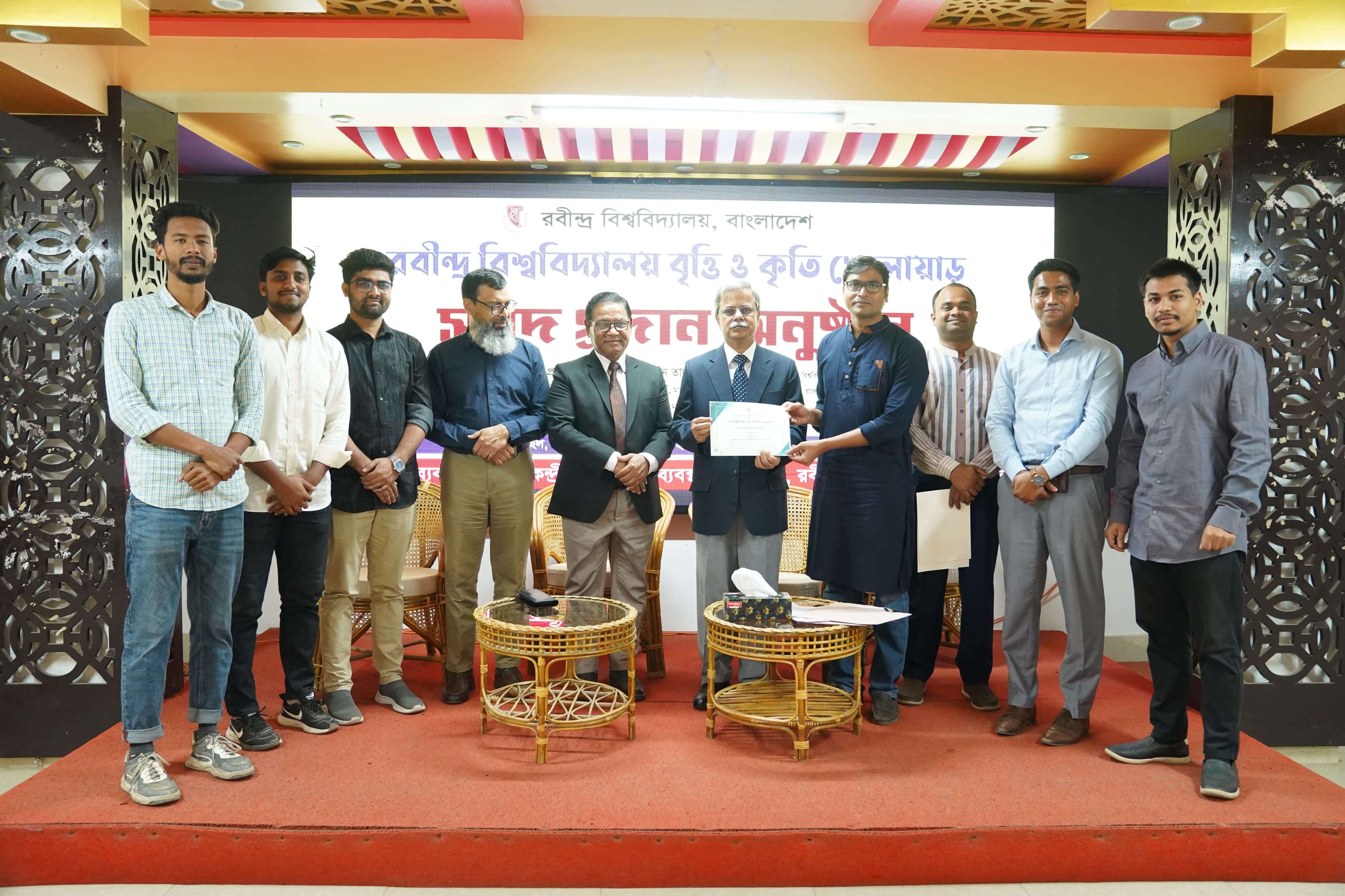 আন্তঃবিভাগ ফুটবল ও আন্তঃবিভাগ ভলিবল টুর্নামেন্ট ২০২৫-এ চ্যম্পিয়ন হওয়ায় মাননীয় উপাচার্যের কাছ থেকে সনদ গ্রহণ করছেন বাংলা বিভাগের চেয়ারম্যান, শিক্ষকমণ্ডলী, খেলোয়াড়বৃন্দ ও শিক্ষার্থীরা।