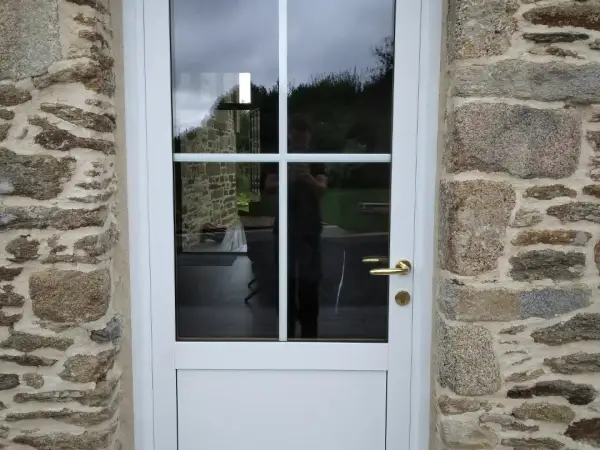 Pose d'une porte mixte alu blanc sur façade en pierre, par Agencement Lennon à Landivisiau, nord Finistère