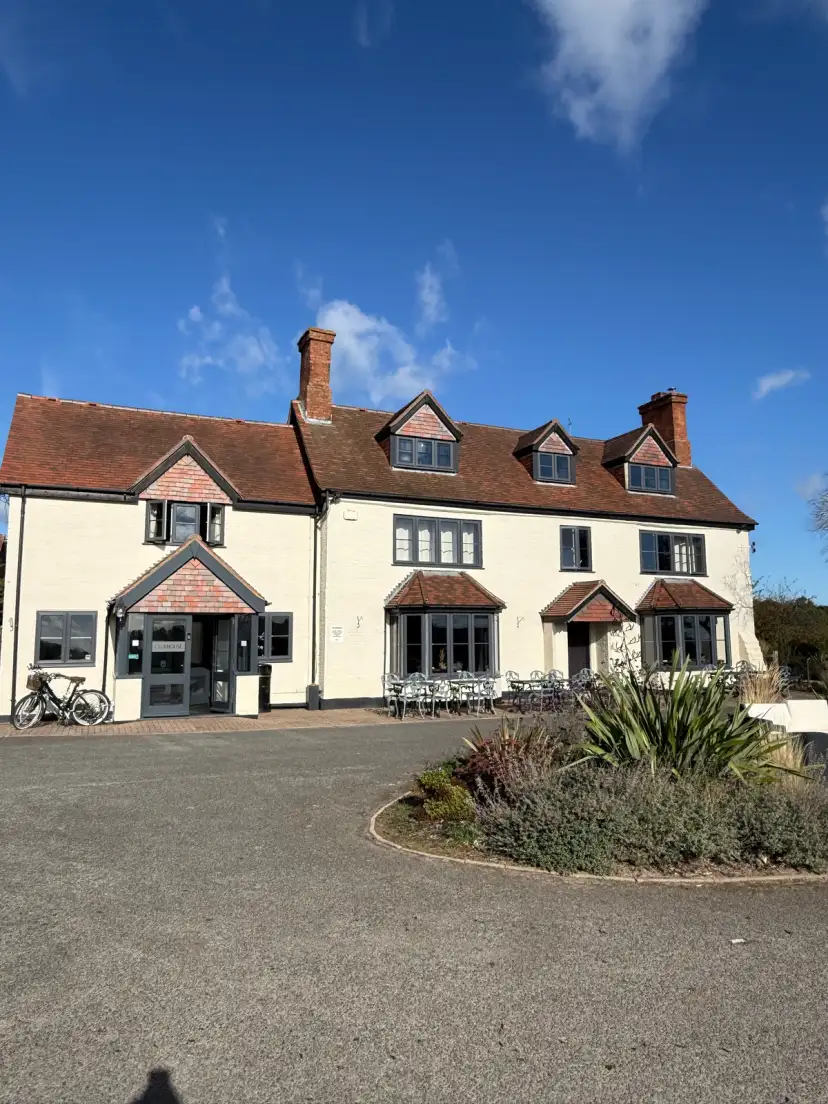 Grand entrance to Stratford Park Hotel and Golf Club set back from the road with open green space and golf course grounds visible beyond