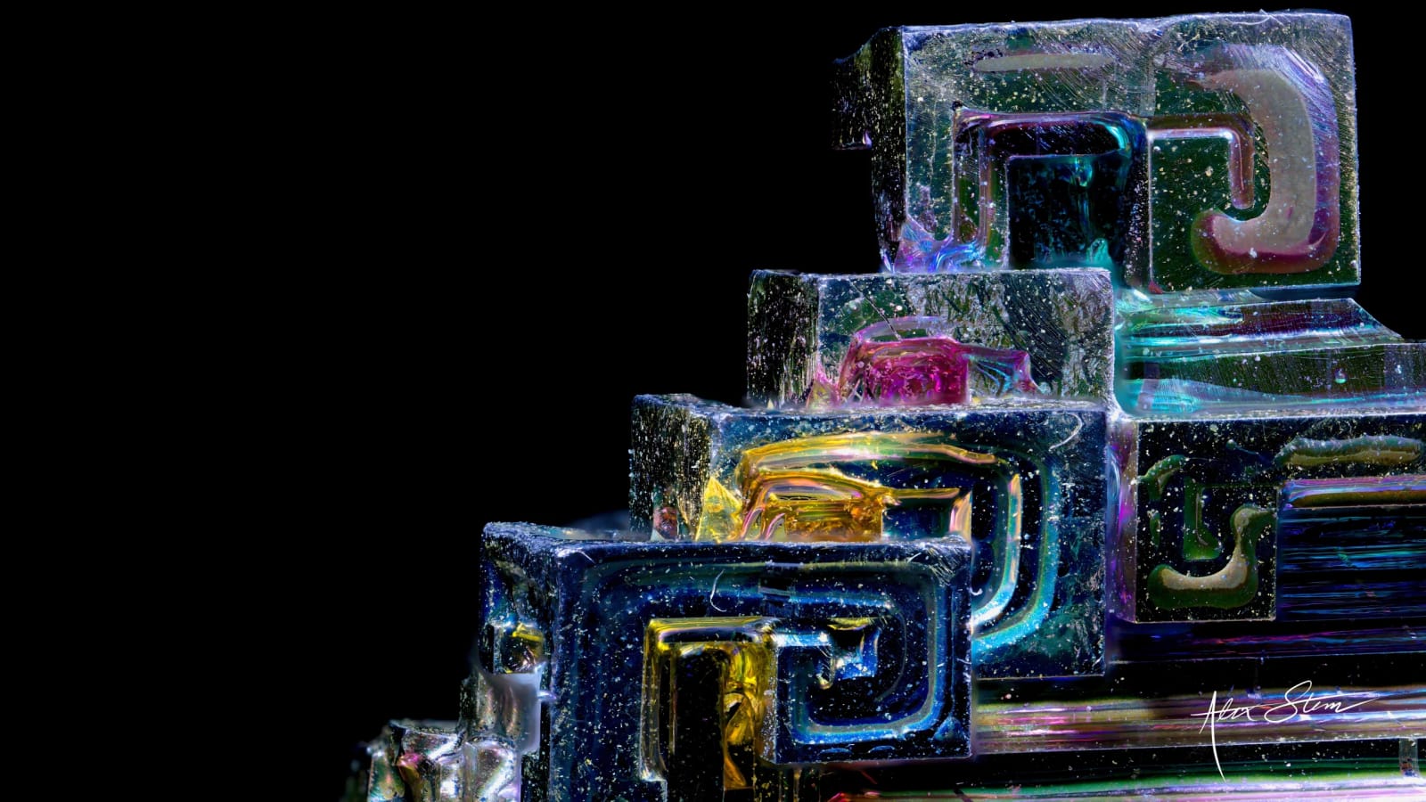 A stepped, iridescent bismuth crystal formation with a dark background.