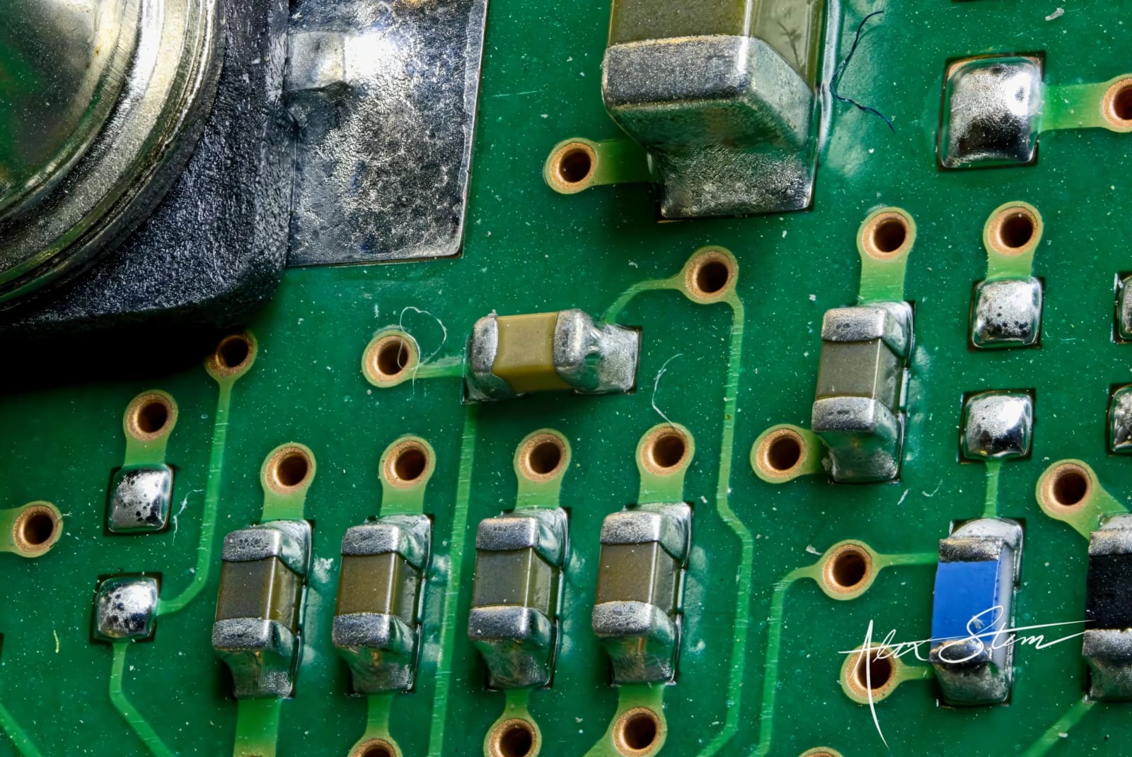 A close-up view of a green circuit board with various electronic components and connectors.