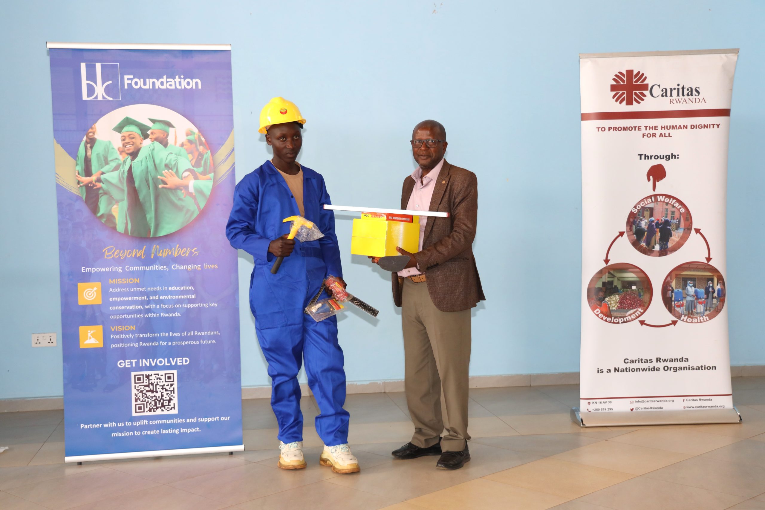 Ntakirutimana Jean, the Deputy Chief of Party of Caritas Rwanda’s Igire-Gimbuka, distributing the startup kit to one of trainees who successfully accomplished his construction professional training.