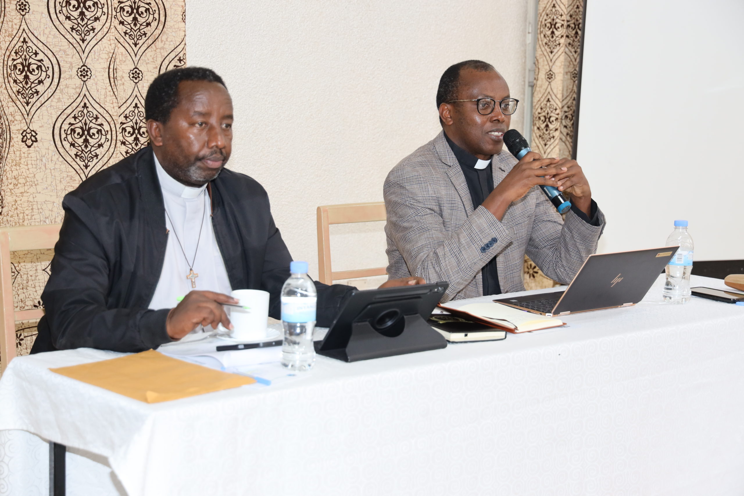Father Oscar Kagimbura, the Secretary General of Caritas Rwanda delivering his speech (during the Nyundo/Gisenyi meeting) and Father Jean Paul Rutakisha, the Director of Caritas Nyundo/Gisenyi.