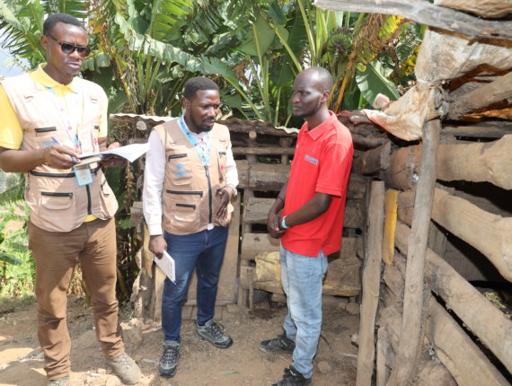 Tito Sindahera, one of the Graduation participants who raise pigs, and the Project staff during the post-distribution monitoring.