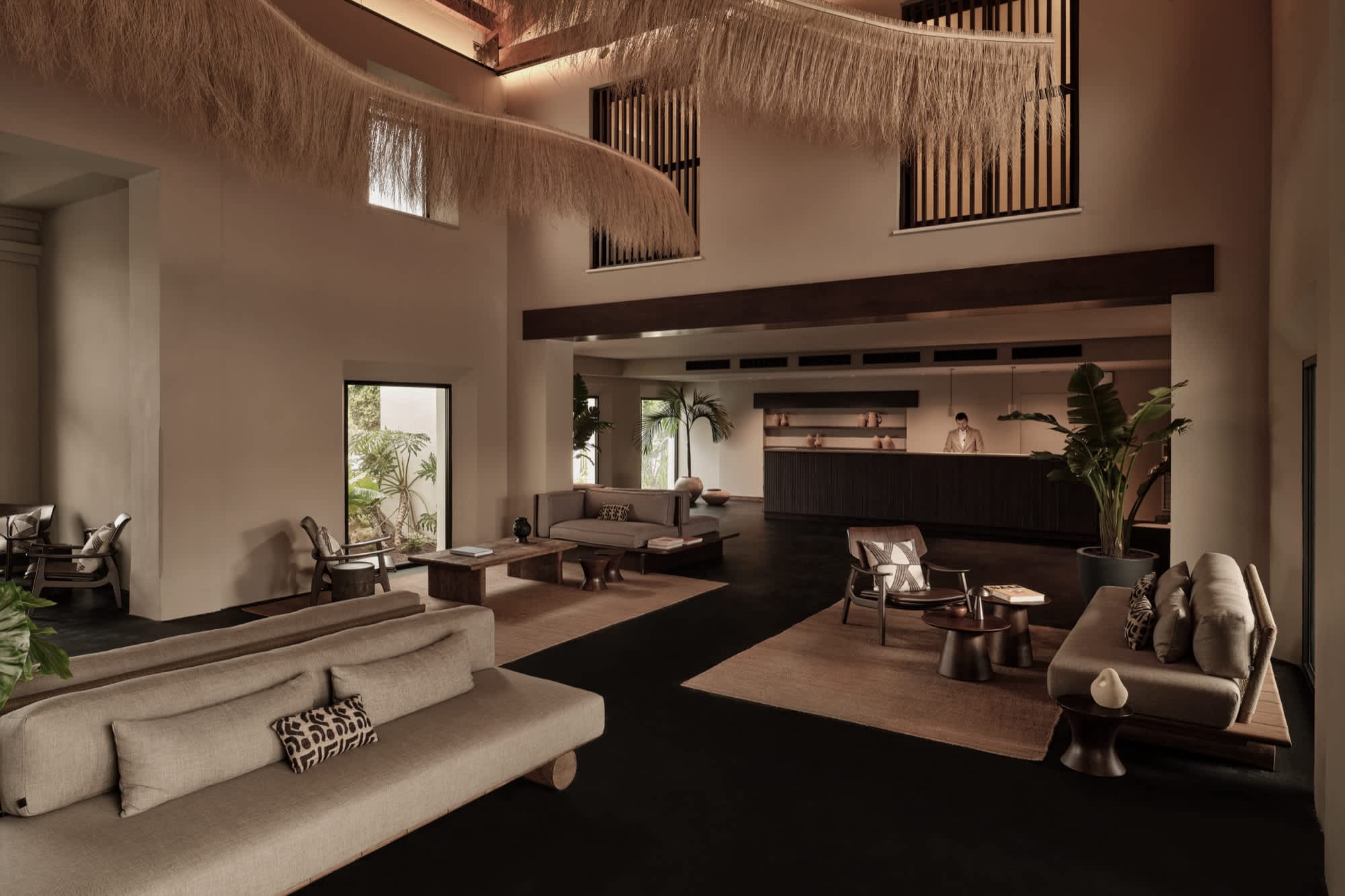 The OKU Andalusia lobby — thatched ceiling, lounge seating and reception.