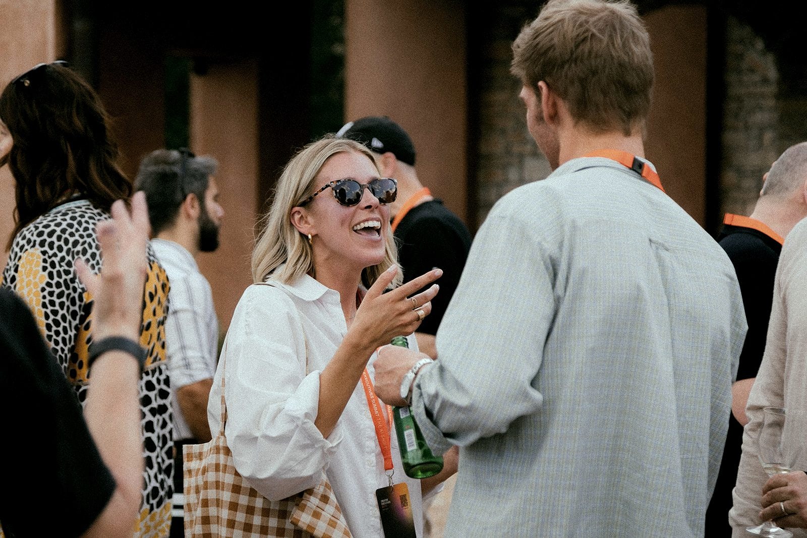 Attendees laughing over drinks at the welcome reception.