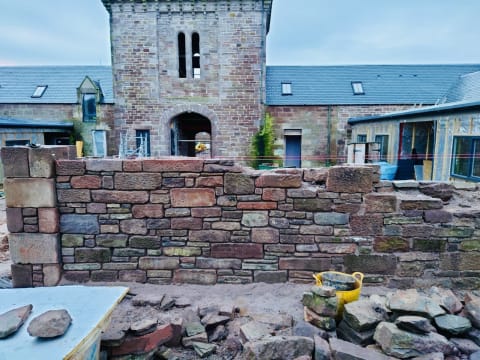 Reclaimed stone wall with water tower at Sunnyside Estate - Masowa & Son