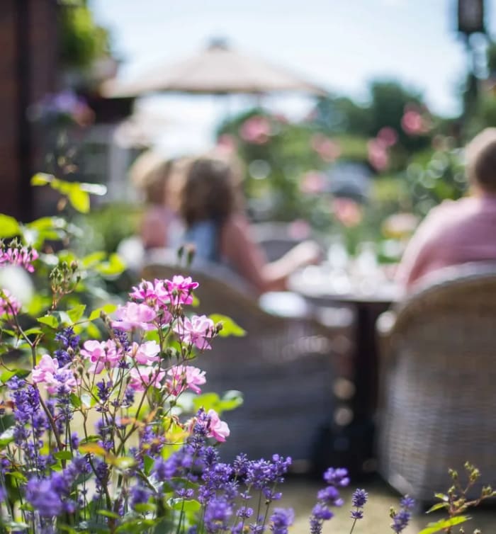 A family enjoying a relaxed alfresco meal in a stunning Montrose Landscapes garden, expertly designed for beauty, connection, and timeless outdoor living.
