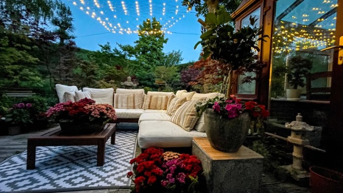 Luxury outdoor garden lounge in Surrey, designed by Montrose Landscapes, featuring ambient lighting and lush greenery.