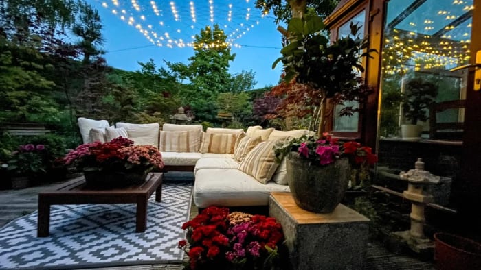 Luxury outdoor garden lounge in Surrey, designed by Montrose Landscapes, featuring ambient lighting and lush greenery.
