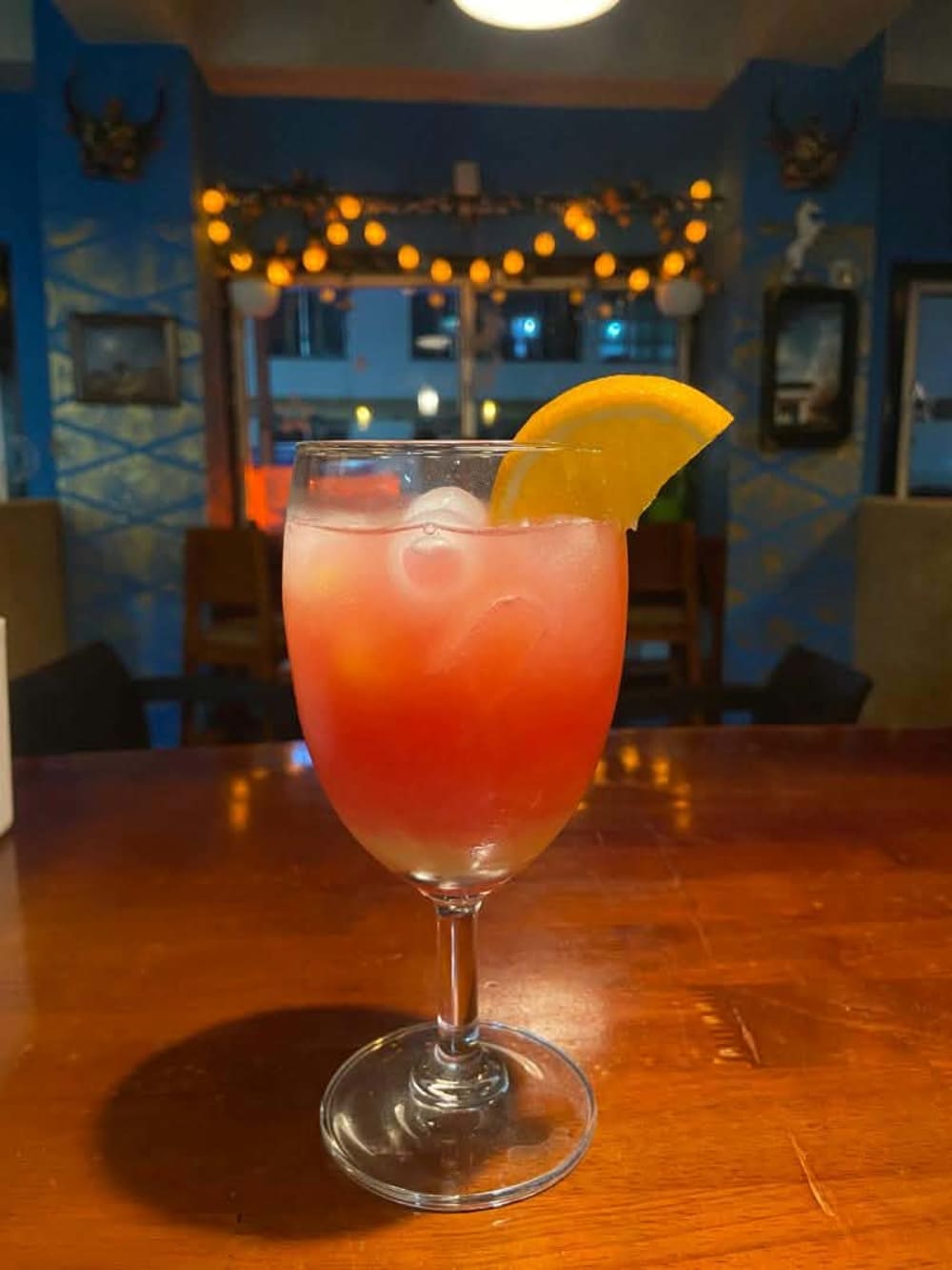 Pink cocktail with an orange garnish at Smilers near Clock Tower Square, Thimphu