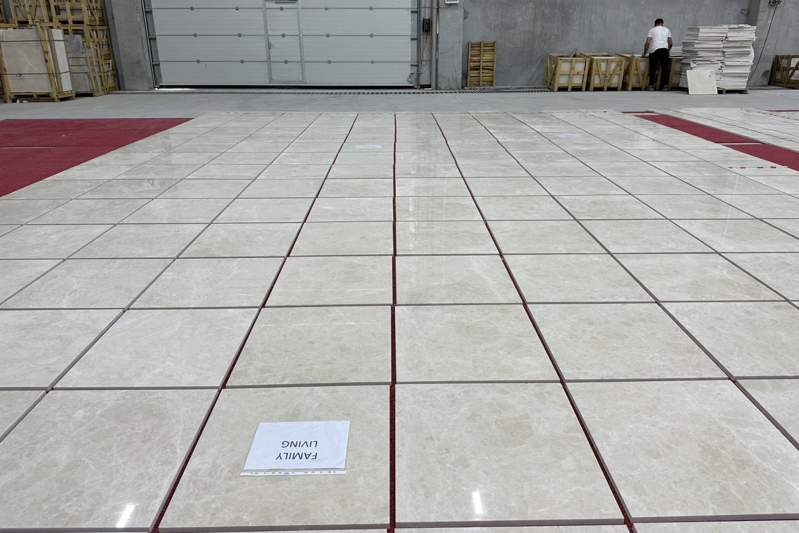 An inspector measuring edge straightness and squareness across the dry-laid layout