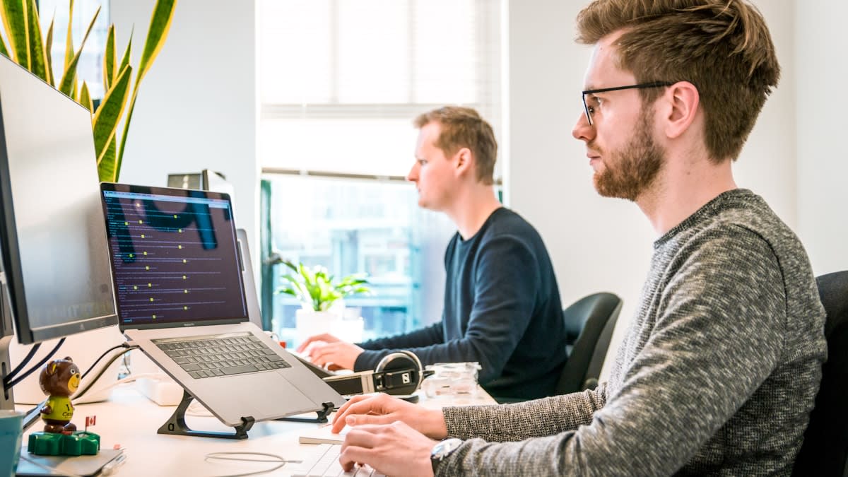 AI productivity tools for documents, email, planning, and teamwork Professional team using productivity software and AI tools on laptops in an office