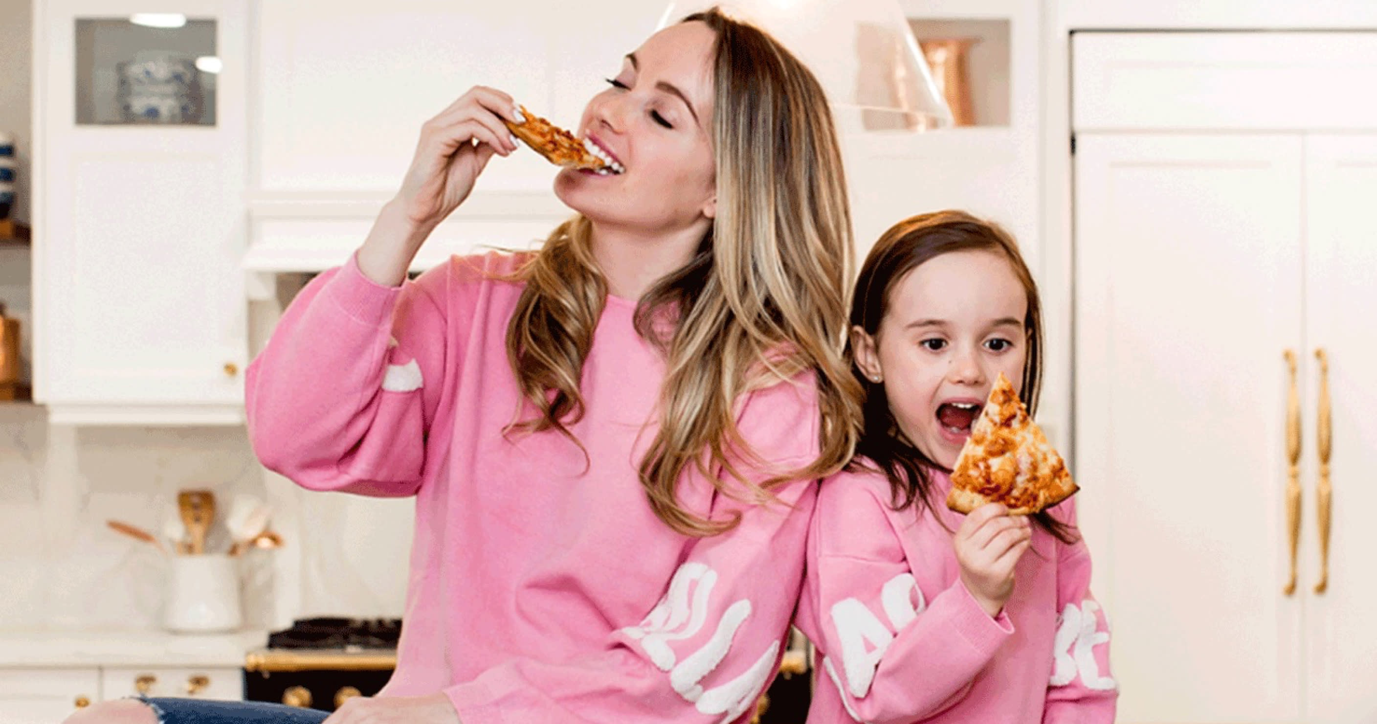 Mother and daughter wearing pink and enjoying CAULIPOWER pizza